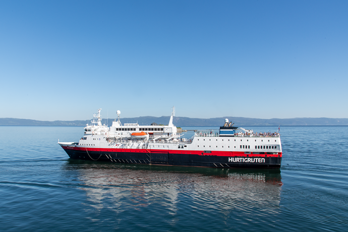 Een Hurtigrutenschip vaart voorbij.